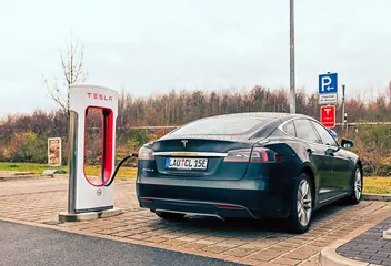 A Model S connected to a red-and-white Supercharger at a station in Germany